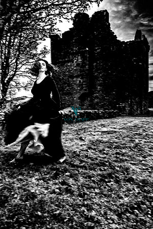 Fashion-Glamour photo of a sexy woman in period Highland clothing in front of a Scottish castle.