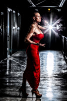 Edgy fashion glamour photograph of a tall bald beauty in a slinky red dress, singing.