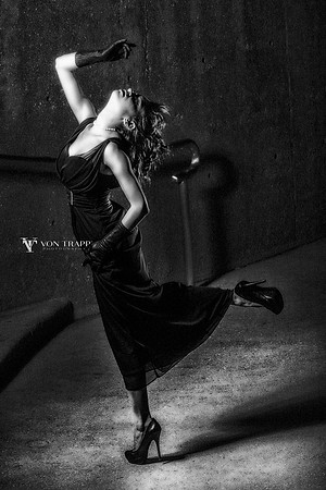 Fashion photo taken at night of a woman in a long gown, opera gloves and heels.