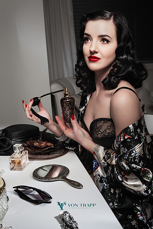Boudoir photo of a raven haired beauty sitting at her dressing table,  photographed in the old Hollywood Glamour style.