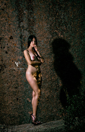 Art nude photo of a tall sexy ravin-haired beauty outdoors in the Texas Hill country, wearing 6 inch fuck me heels.