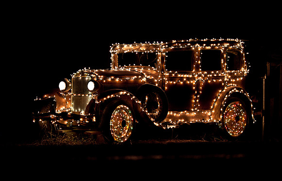 A turn of the century car decorated for Christmas.