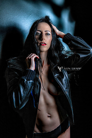 Fashion-glamour photo of a sexy woman, topless wearing a leather jacket and panties.