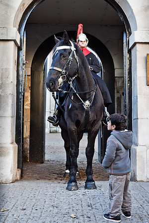 A horse an soldier of the Royal Horse Guards tower over a young boy onlooker.