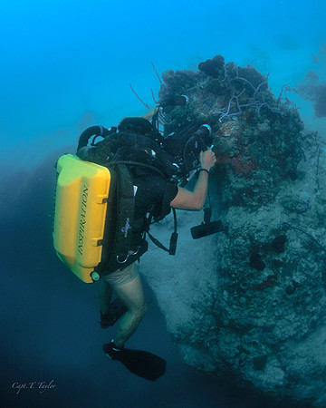 Underwater photo of a technical diver videoing an early invasion of lion fish while using a closed circuit rebreather in a blue hole, Bahamas.