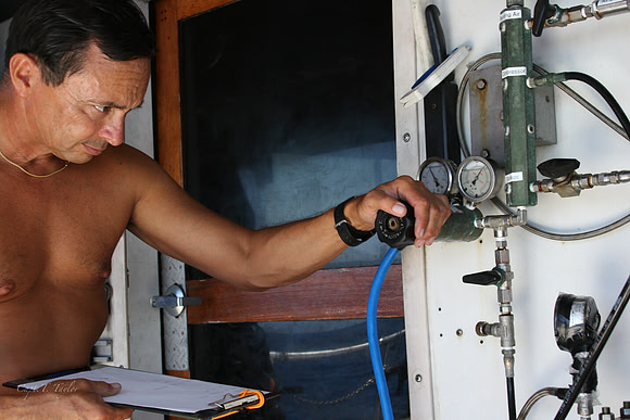 Photo of a technical diver blending TRIMIX aboard a boat.