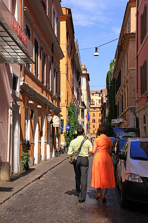 Photo of a couple taking stroll arm in arm in Rome, Italy.