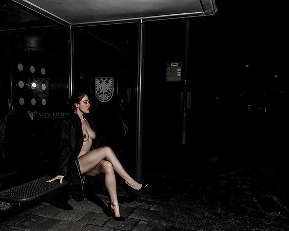 Art nude photo of a woman sitting at a Dutch bus stop in Naarden, Holland.