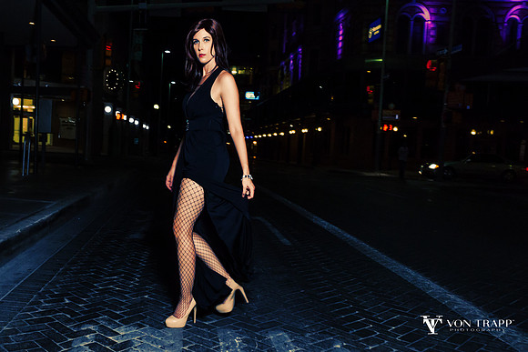 Hot photo of a woman on a San Antonio street at nighttime.