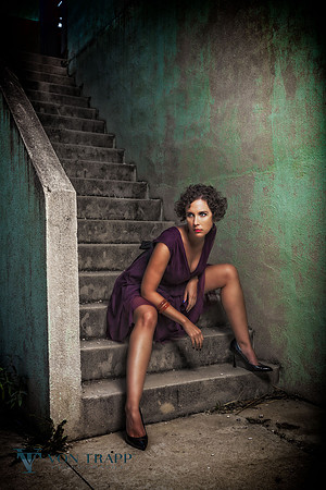 Edgy fashion photo of a hot woman sitting on stairs in a dress with her legs spread.