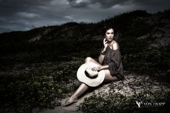 Fine art photo of a woman sitting on a beach in Texas during stormy weather.