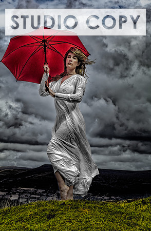 Fine art photo of a sexy blonde wearing a white chemise and holding an umbrella, standing on a hill in Wales.