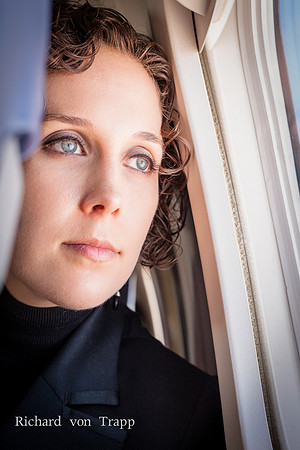 Portrait of a woman gazing out the window of an airplane.