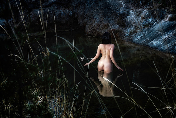 Color Fine Art Nude photo of a woman standing in a pond.