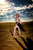 Art nude photo for sale  a woman dressed in gauze skirt and head scarf, posed on a sand dune in a desert.
