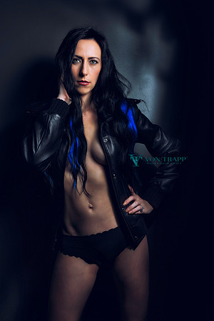 Glamour photo of a woman in a leather jacket and panties.