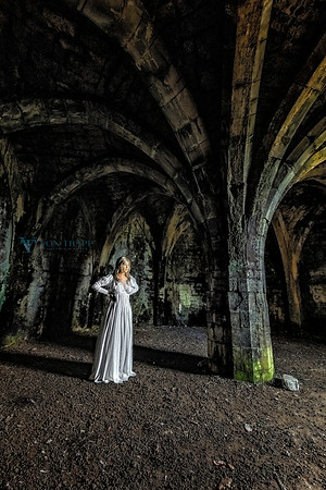 Fine art photo of a woman wearing a period chemise, posed in the ruins of a Welsh castle.