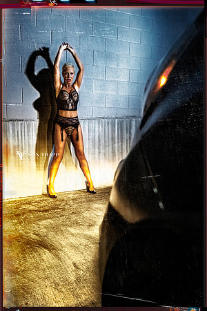 Edgy Fashion photo of a woman in lingerie caught by a car's headlights in public.