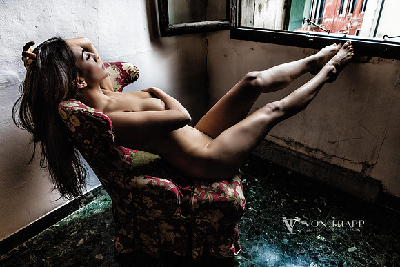 Art nude of a woman by a window in a palazzo in Venice.