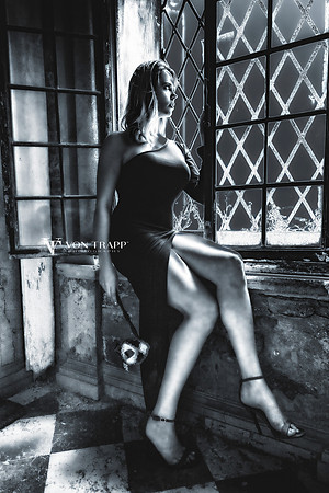 Fine art photo of a woman in a high slit gown, and heels, sitting on a window ledge in a Venetian palazzo.