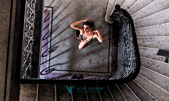 Fashion photo of a woman wearing lingerie and standing in an interesting European stairway in Budapest.