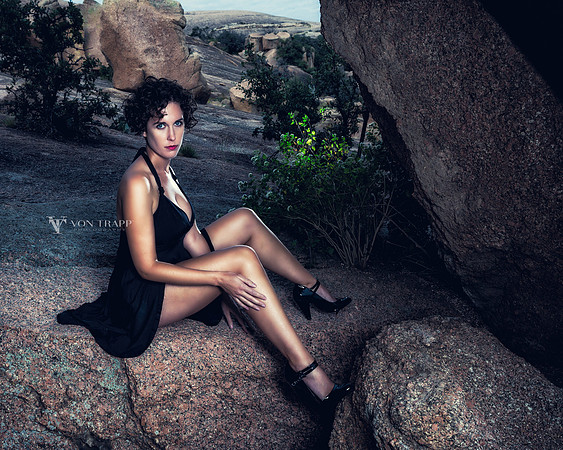 Sexy portrait of a woman in a short dress and heels, posed in the desert.