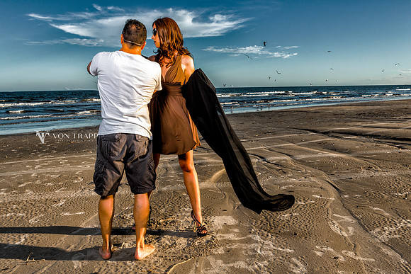 Behind the scenes photograph of photographer working with a model on a Texas beach.