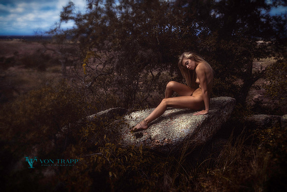Art nude photo of a woman among huge stones at Enchanted Rock State Park.