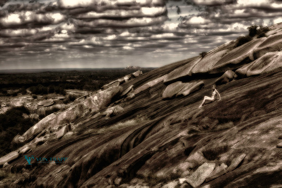 Art nude photo of a woman among huge stones at Enchanted Rock State Park.