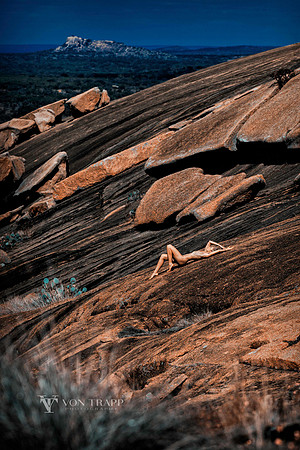 Art nude photo of a woman among huge stones at Enchanted Rock State Park.