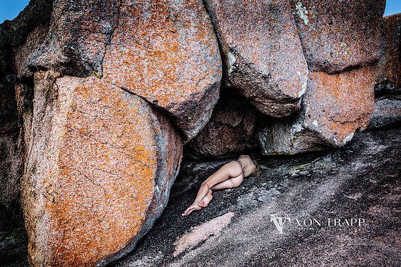 Art nude photo taken at Enchanted Rock Texas off a woman laying under a rock opening.