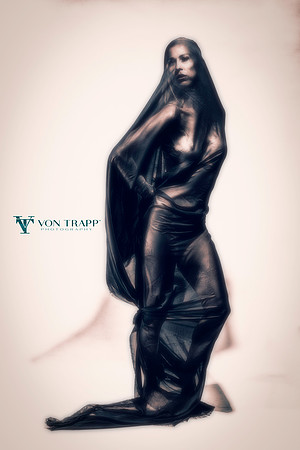 Art nude photo of a woman covered in black cloth.