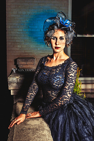 Stylized fine art portrait of a woman in black lace, tulle, and fascinator.