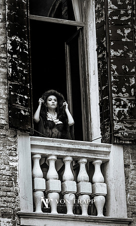 Beautiful chic woman at a grand window in a Venice palazzo, Italy.