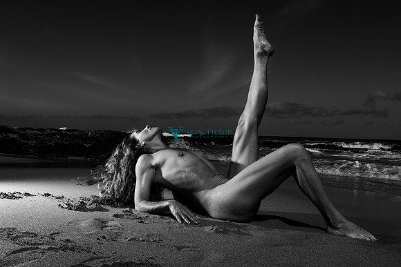 Art nude photo of a woman laying on a beach in Kauai.