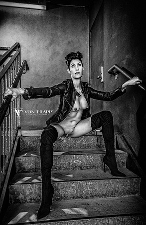 Erotic art nude photo of a hot woman sitting, spread leg, on a stairway.