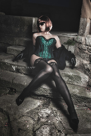 Sexy photo of a redheaded woman wearing a corset, stockings, and gloves outdoors ant night in the German mediaeval town of Rothenburg.