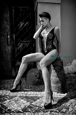 Photo of a sexy and leggy woman wearing lingerie in public on a street in Prague.