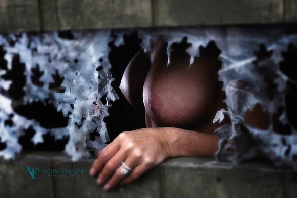 Photo of a nude woman's breasts (boobs) peeking out from the window of a dear hunting hide.