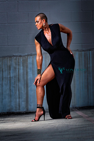 Photo of a sexy and leggy bald woman in a high slit dress.