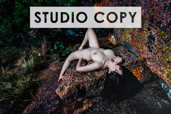 Color art nude photo of a woman reclined on a boulder of granite in the Texas Hill Country.