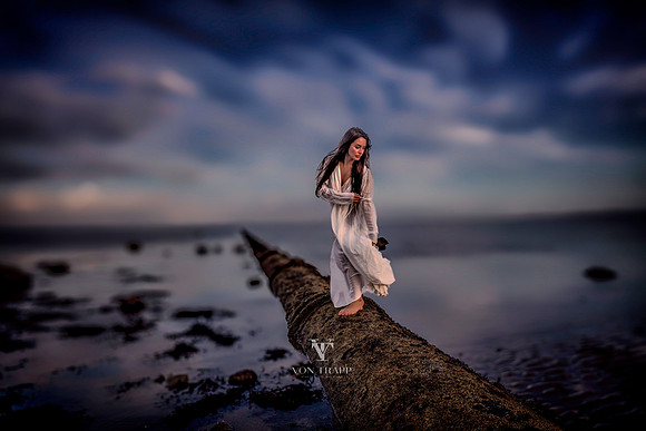 Fine art photo of a woman in a vintage-inspired chemise, posed on a large pipe leading into the Frith of Clyde, Scotland..