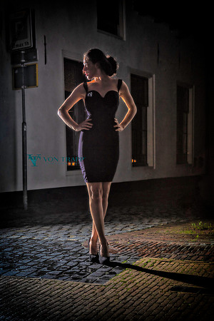 Fine art photo of a woman in a sexy dress in a cobbled street in Naarden, Holand.
