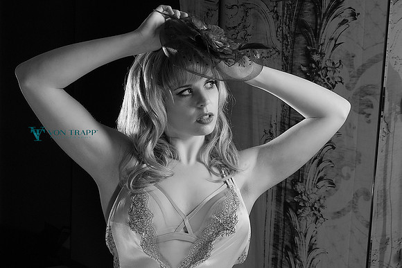 Emotive boudoir photo of a woman in lingerie and a fascinator.