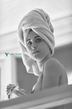 Voyeur glamour photo of a topless woman seen through her bedroom window.