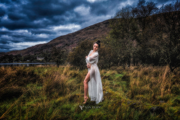 Fashion-Glamour photo of a sexy woman in a sheer gown, posed in a field in Scotland.