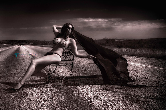 Photo of a woman in a sexy bathing suit, sitting on a chair on a roar in west Texas.
