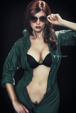 Edgy photo of a sexy woman flashing while wearing a flight suit.