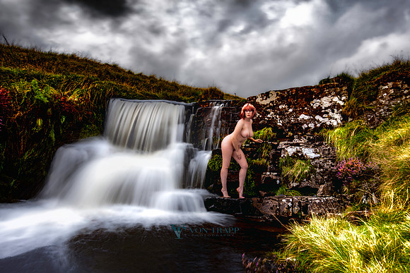 Fine art nuse photograph taken in Wales of a hot redhead posed by a waterfall.