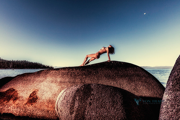Fine art nude color photograph of a woman posed on a hught boulder in Lake Tahoe, NV.